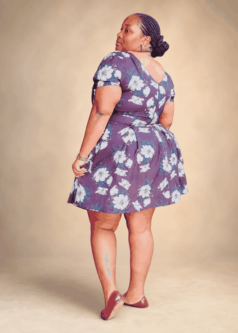 Bravtone50 woman showing the back fit of a purple floral dress