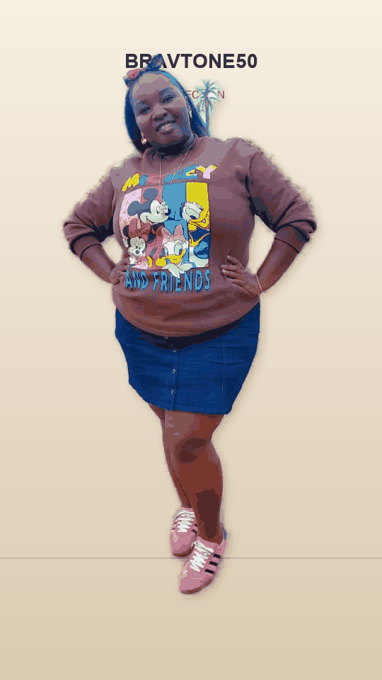 Bravtone50 woman wearing a graphic sweatshirt, denim skirt and pink trainers